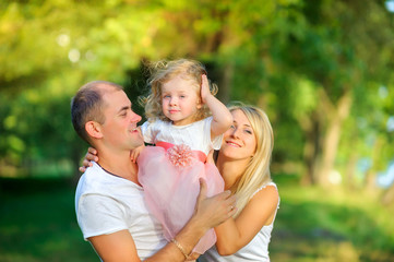 Fototapeta premium Loving family . Happy young family spending time together having fun in summer park, people concept. Family еnjoying time together