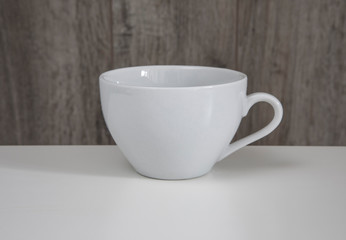 Empty white mug on a wooden table.