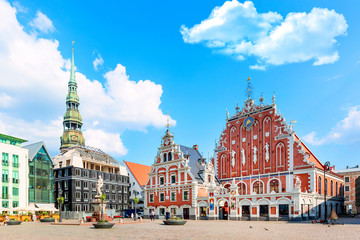 View of the Old Town Ratslaukums square, Roland Statue, The Blackheads House near St Peters Cathedral against blue sky in Riga, Latvia. Summer sunny day - obrazy, fototapety, plakaty