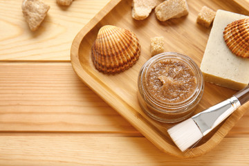 Fototapeta na wymiar Jar with sugar scrub and ingredients on wooden table