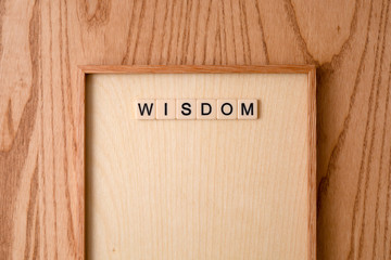 WISDOM word block on wood background. 