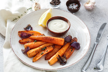 Plate with tasty cooked carrot and sauce on grey table