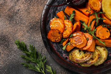 Plate with tasty cooked vegetables on dark table