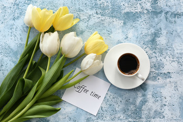 Composition with beautiful tulips and cup of coffee on color background