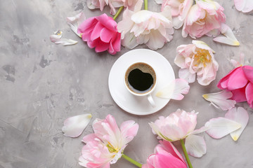 Beautiful tulips with cup of coffee on grunge background