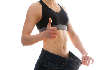 The concept of diet and weight loss. Woman in big jeans on white background 