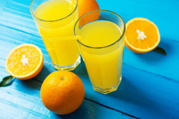 Freshly squeezed orange juice in the glass. Cut ripe oranges