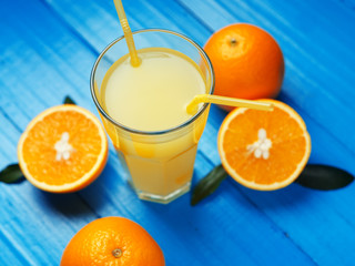 Freshly squeezed orange juice in the glass. Cut ripe oranges