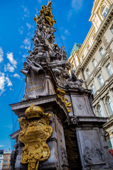 Fototapeta na wymiar Plague column in Vienna on the background of the building and the blue sky