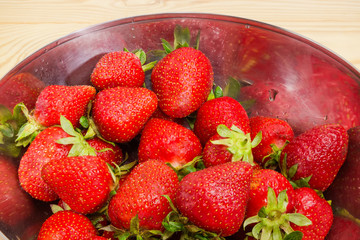 Washed strawberries in stainless steel bowl close-up