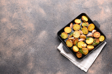 Frying pan with tasty baked potato on grey table