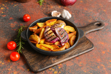 Frying pan with tasty baked potato on table