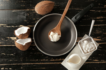 Frying pan with coconut oil on dark wooden table
