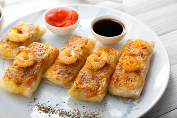 Tasty fried spring rolls on plate, closeup