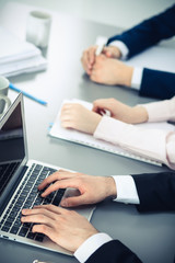 Group of business people working together in office. Man hands typing on laptop computer