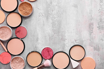 Different facial powder and blusher on grunge background