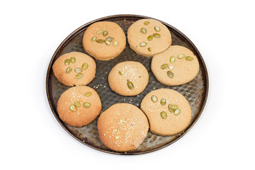 Baked homemade cookies sprinkled with different seeds on baking tray