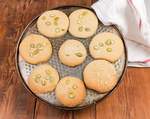 Baked homemade cookies sprinkled with different seeds on baking tray