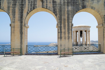 World War II Siege Bell War Memorial through arches in the Lower Barrakka Gardens, Valletta, Malta