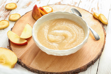 Bowl with healthy baby food on wooden background