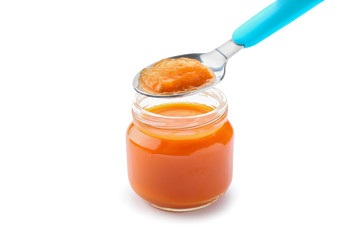 Jar with healthy baby food and spoon on white background