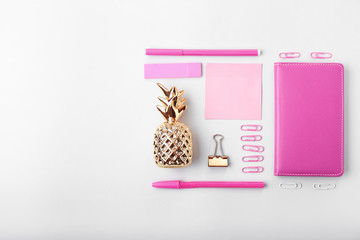 Composition with golden pineapple and stationery on white background