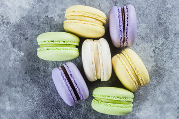 Cake macaron or macaroon on gray background from above. Colorful almond cookies, pastel colors. Top view, flat lay