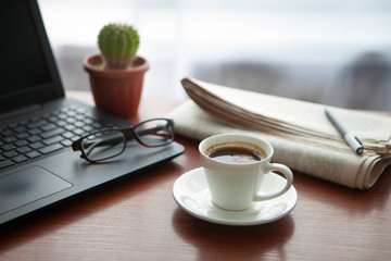 Newspaper with computer on table. Coffee break. 