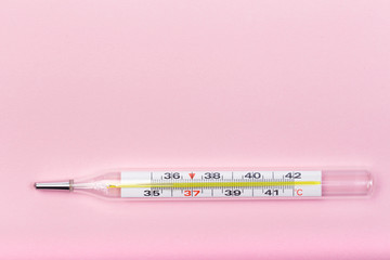 medical  thermometer  on pink   background close up view