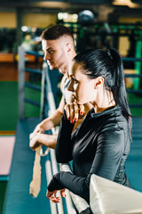 beautiful athletic girl and a young guy stand in a boxing ring