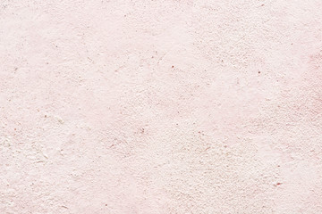Light pink texture or background of stucco or plaster wall, close-up.