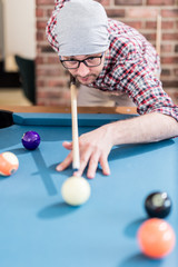 Portrait of hipster man playing billiards.