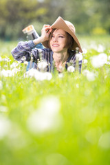 Happy spring woman on dandelion field enjoying spring warm days