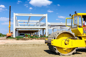 Road roller with spikes is working at construction site