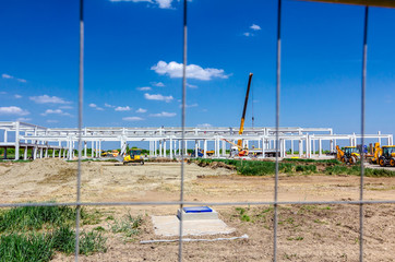 Fototapeta na wymiar View on the construction site through a fence wire