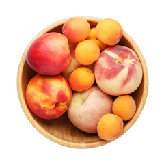 Fototapeta na wymiar Fresh ripe peaches, apricots and nectarines in wooden bowl isolated on a white background. Top view, close-up.