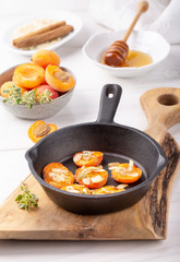 Grilled apricots in cast-iron pan.  Apricots baked with almonds, honey and thyme. Healthy dessert