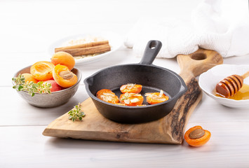 Grilled apricots in cast-iron pan.  Apricots baked with almonds, honey and thyme. Healthy dessert