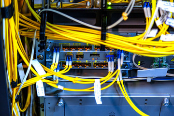 Close up telecommunication working data device Fiber optical cables connect to interface, multiple information technology computer, network router