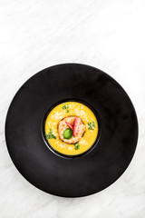 Homemade pumpkin cream soup on dark plate