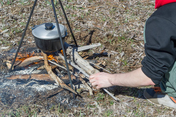 Cooking on a fire at spring. Close view of caldron over the campfire.