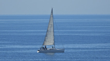 Zoom photo of sail boat sailing the Aegean deep blue sea
