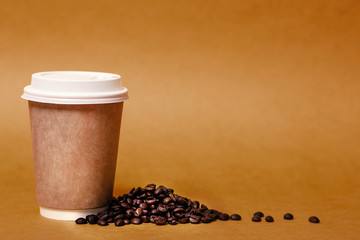 Paper cup and grains of coffee