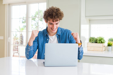 Young man using computer laptop screaming proud and celebrating victory and success very excited, cheering emotion