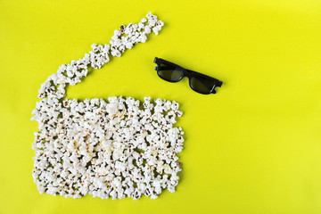 Concept love movie, pastime, entertainment and cinema. Popcorn movie clapper and 3d glasses on yellow background.