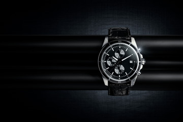 Fototapeta Nice luxury man's wrist watch on dark background. Stainless steel man's wrist watch with black leather strap. obraz