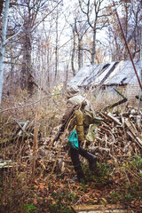 Stalker, a guy in uniform and with a gun walks in the yard of an old ruined house in the forest