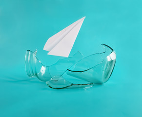 Freedom and dreams concept. Broken cage, free flight. Paper plane broke jar. Isolated on blue...