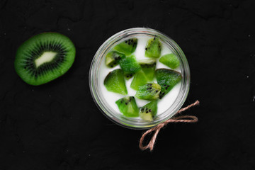 Yogurt with kiwi slices on a black background
