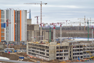 Construction site, construction of a large residential complex, many tower cranes and construction equipment
